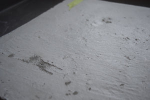 Sample of a piece of concrete slab with sample identification tag in the background