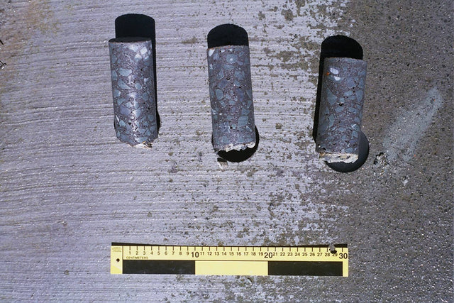 Three concrete core samples next to a ruler